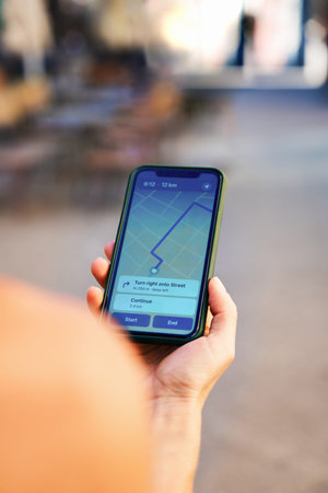 Close-up using mobile phone with digital map showing travel direction