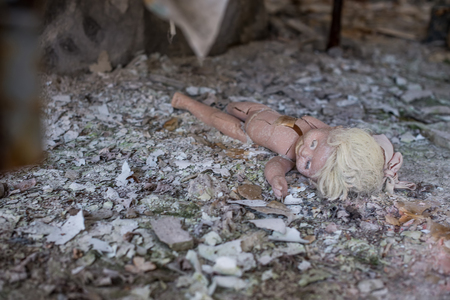 Abandoned kindergarten in Chernobyl Exclusion Zone. Lost toys, A broken doll. Atmosphere of fear and loneliness. Ukraine, ghost town Pripyat.の写真素材