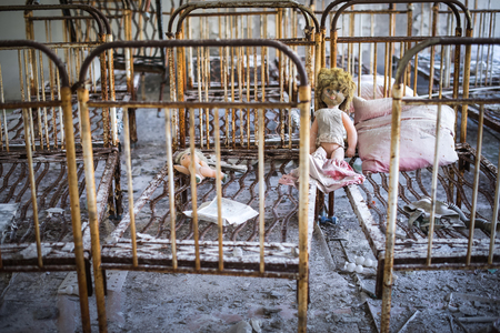 Abandoned kindergarten in Chernobyl Exclusion Zone. Lost toys, A broken doll. Atmosphere of fear and loneliness. Ukraine, ghost town Pripyat.の写真素材