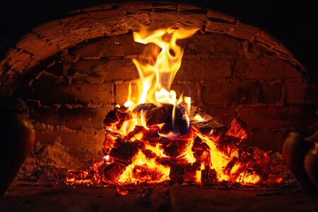 Village stove firewood and fire. Burning wood inside traditional ovenの写真素材