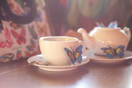 cup of tea with Handmaid butterflies on a background of handbagsの写真素材