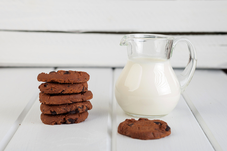 glass jug with milk and chocolate chip cookiesの写真素材