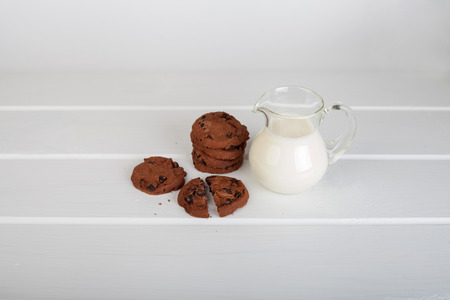 glass jug with milk and chocolate chip cookies