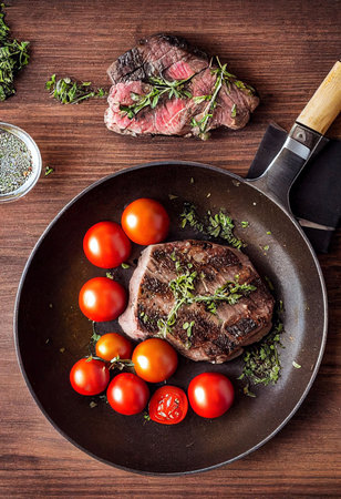steak with rosemary and spices grilled with tomatoes and spicesの写真素材
