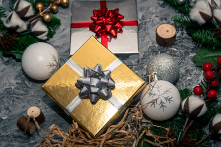Golden and silver gift boxes with baubles, greenery and wood shavings creating a festive Christmas still life top view.の写真素材