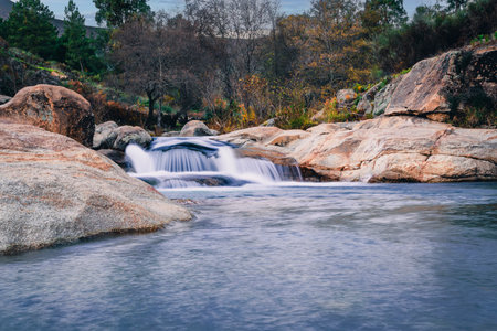 Small waterfall in El Jevero natural pool, Acebo (Caceres), mountain river flowing over granite...
