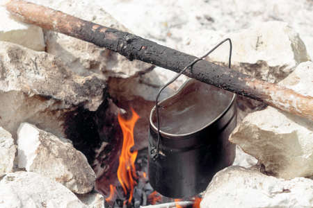 USSR army pot of water hanging on a stick over a fireの写真素材