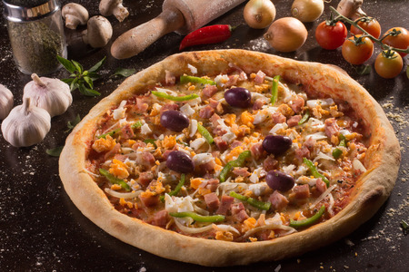 Traditional Portuguese Pizza with olives, bell pepper, ham, egg and onionsの写真素材