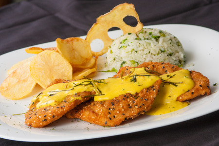 Breaded Fish with mustard sauce, chips and riceの写真素材