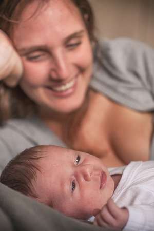 One month baby and his Mother lying in bed