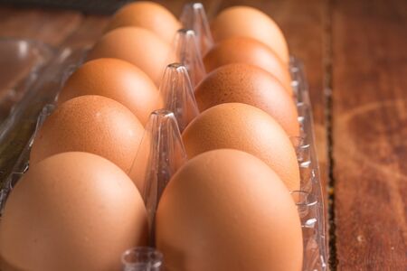 Transparent Egg Box over a wooden table