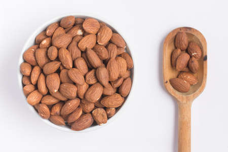 Almonds into a bowl on white backgroundの写真素材