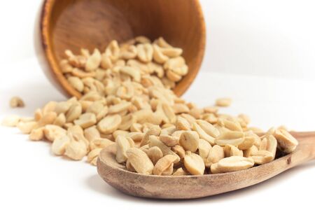 Peanuts into a spoon over a white background. Close-up photoの写真素材