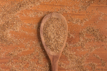 Ground Wheat into a spoon over a wooden table.の写真素材