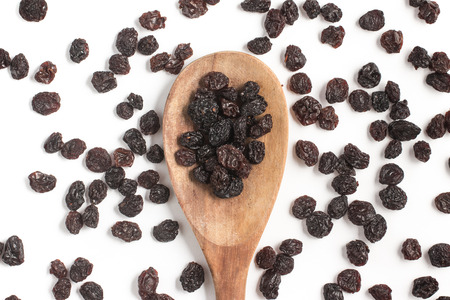 Dried Grapes into a spoon isolated in white backgroundの写真素材