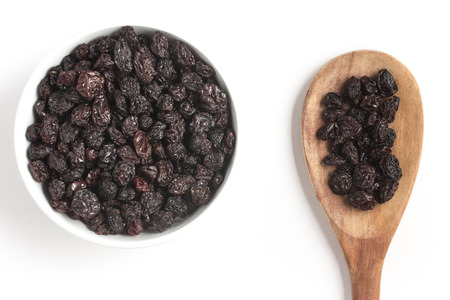Dried Grapes into a bowl isolated in white backgroundの写真素材