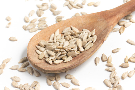 Sunflower Seeds into a spoon isolated in white backgroundの写真素材
