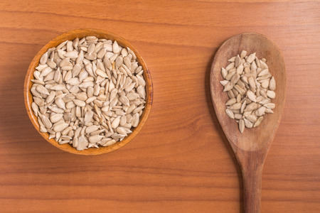 Sunflower Seeds into a bowl over a wooden tableの写真素材