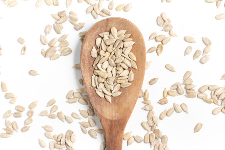 Sunflower Seeds into a spoon isolated in white backgroundの写真素材