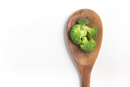 Broccoli into a spoon isolated in white backgroundの写真素材