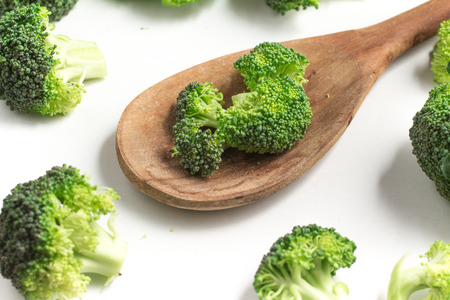 Broccoli into a spoon isolated in white backgroundの写真素材