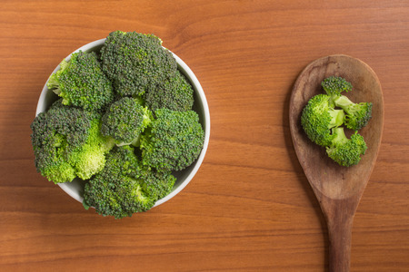 Broccoli into a bowl over a wooden tableの写真素材