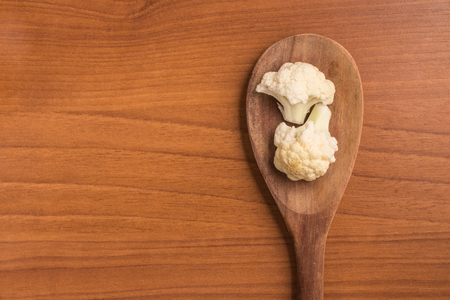 Cauliflower Cabbage into a spoon over a wooden tableの写真素材