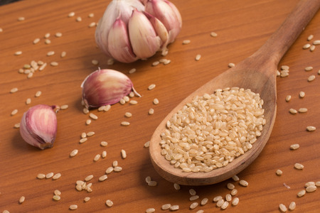 Integral Rice into a spoon. Wholegrain. Cateto over a wooden tableの写真素材