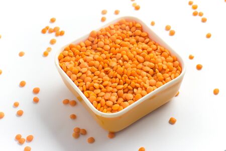 Red or Canadian Orange Lentil into a bowl isolated on white backgroundの写真素材