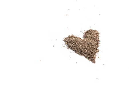 Cumin Seeds heart shaped isolated on white backgroundの写真素材