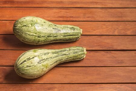 Raw fresh zucchini over a wooden tableの写真素材