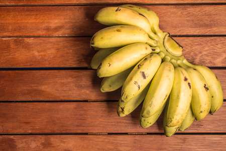 Lady Finger Banana Ouro over a wooden tableの写真素材