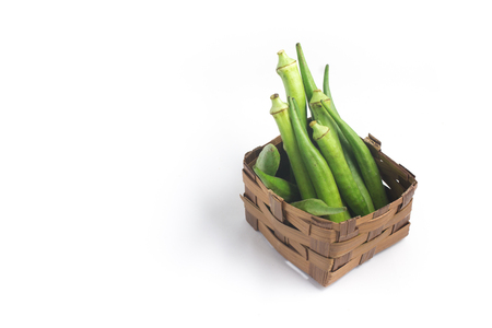 Okra into a basket isolated on white backgroundの写真素材
