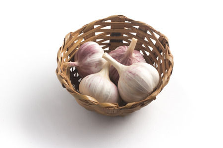 Mini or Baby Garlic into a basket isolated on white backgroundの写真素材
