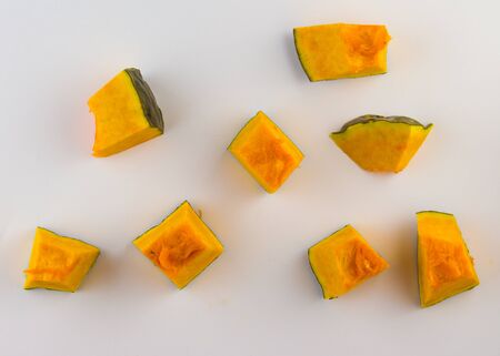 Sliced Pumpkin Cubes with peel on white backgroundの写真素材