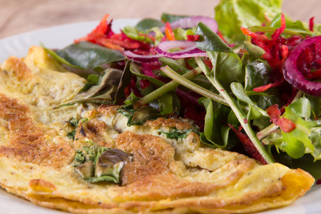 Mix Leaf Salad with omelet over a wooden tableの写真素材