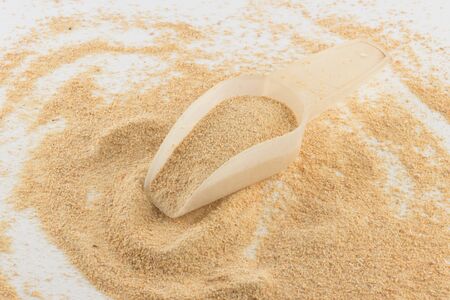 Toasted manioc flour into a spoon isolated on white background