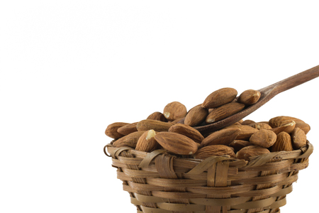 Almonds in a basket bowl isolated on white backgroundの写真素材