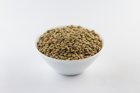 Raw Lentils in a bowl over a white backgroundの写真素材