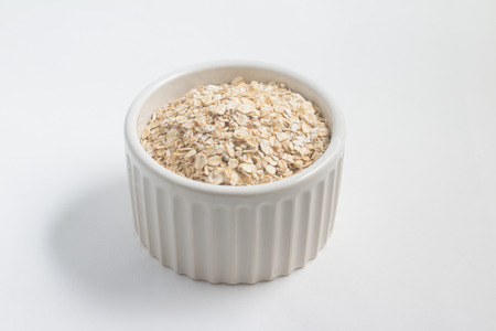 Oat Flakes in a bowl on white backgroundの写真素材