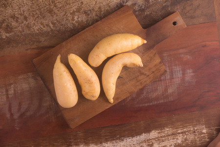 Pile of Mandioquinha baroa potato over a wooden tableの写真素材