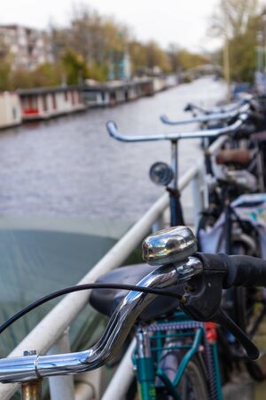 AMSTERDAM, NETHERLANDS - APRIL 13, 2019: Bicycles lining a bridge over the canals of Amsterdam, Netherlands. Close-up Photoのeditorial素材