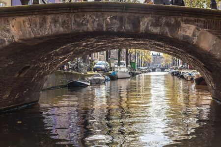AMSTERDAM, NETHERLANDS - APRIL 14, 2019: Houses and Boats on Amsterdam Canal, Netherlands.のeditorial素材