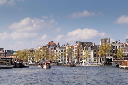 AMSTERDAM, NETHERLANDS - APRIL 14, 2019: Houses and Boats on Amsterdam Canal, Netherlands.のeditorial素材