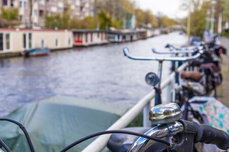 AMSTERDAM, NETHERLANDS - APRIL 13, 2019: Bicycles lining a bridge over the canals of Amsterdam, Netherlands. Close-up Photoのeditorial素材