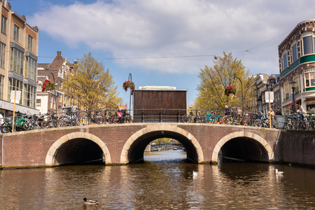 AMSTERDAM, NETHERLANDS - APRIL 14, 2019: Houses and Boats on Amsterdam Canal with a blue skyのeditorial素材