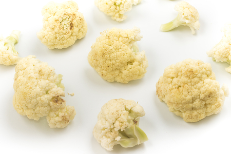 Cauliflower sliced into small pieces on white backgroundの写真素材