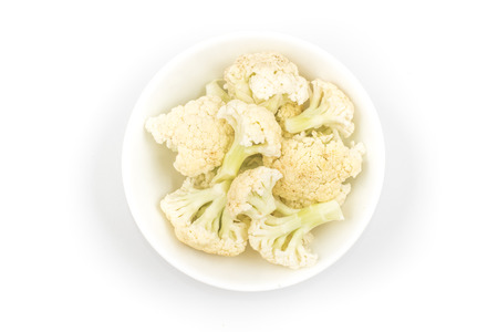 Cauliflower sliced into small pieces in a bowl on white backgroundの写真素材