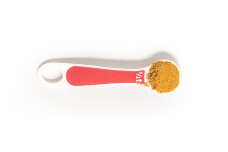 Curry Powder into a teaspoon. Measuring spoon on white backgroundの写真素材