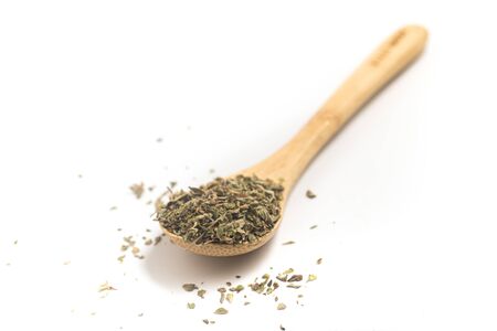 Dried Oregano into a Teaspoon on white backgroundの写真素材
